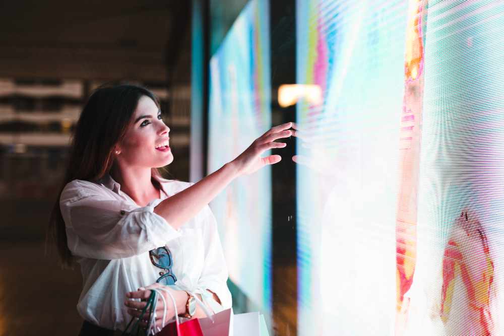 A young woman touching an LED screen